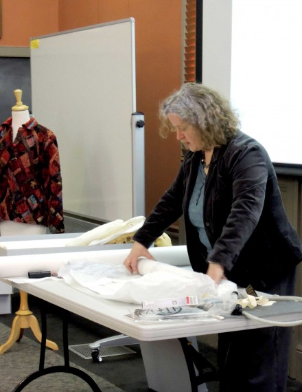 Showing how to roll a textile on a tube